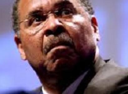 Close up of black man's face with wire rimmed glasses, a moustache and a worried or scared look as he looks up