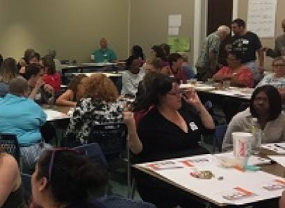 Lots of diverse people sitting at tables in a big room