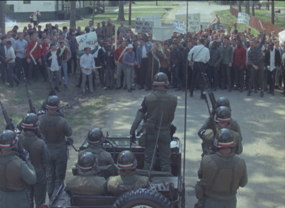 MIlitary looking men facing off a group of people