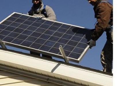 Two guys on a roof installing a solar panel