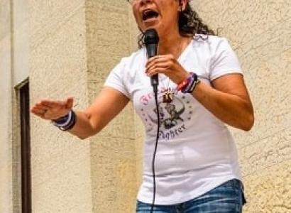 Esther Flores passionately talking into a mic