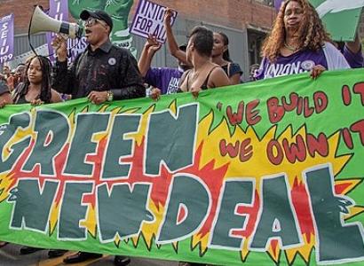 Banner that says Green New Deal and people marching