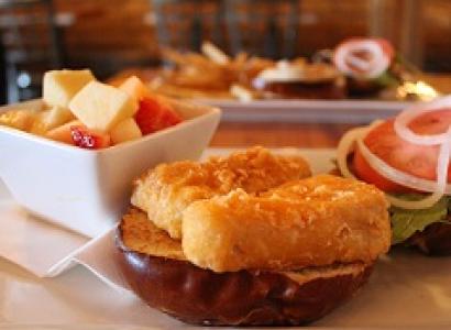 Hamburger-looking bun and food next to lettuce, tomato and other food