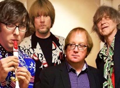 Four white guys one playing a kazoo and looking like rock stars except one guy in the middle with a sport coat on