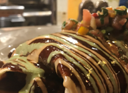 Food on a plate with striped brown and beige sauce on top