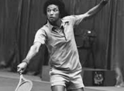 Black and white photo of young black man with afro playing tennis