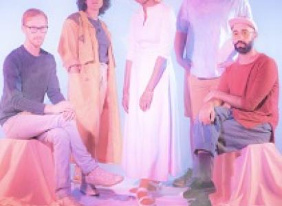 Five people posing two sitting on each side and three standing in the middle