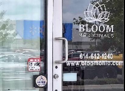 Glass front door of business with words Bloom Medicinals