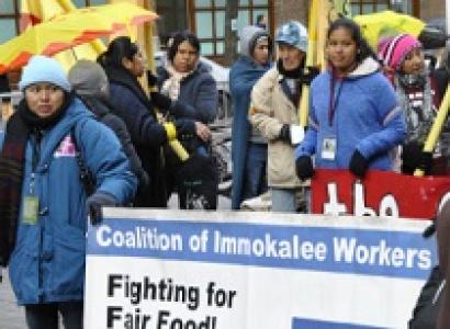 People outside in the cold and rain holding a Fighting for Fair Food sign