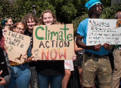 People holding signs at climate strike saying Climate Action Now