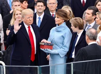Donald Trump frowning with hand on Bible at swearing in ceremony