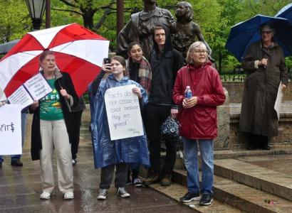 People in rain with signs touting the importance of facts