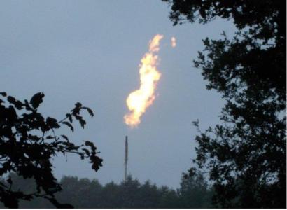 Long shot of firey emission out of smokestack