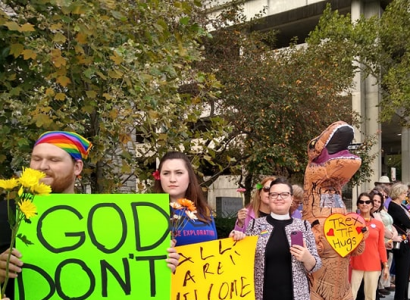Line of counterprotestors holding signs one saying God Don't Hate