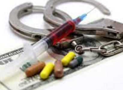 Handcuffs, a syringe, pills and a 100 dollar bill