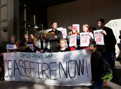 People outside with banner reading ceasefire now