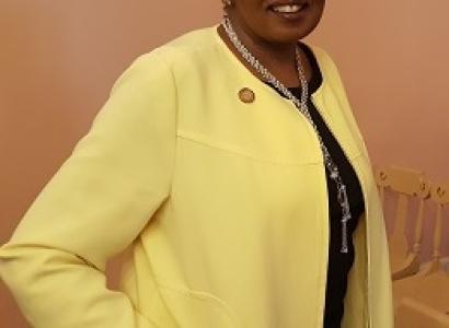 Black woman with updo wearing a yellow suit