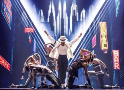 Actor playing Michael Jackson with dancers around on stage