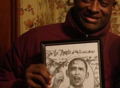 Black man smiling and holding an illustration of Obama