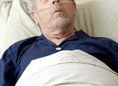 Old man with oxygen in his nose, in a bed