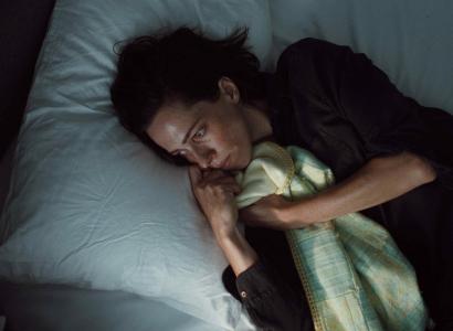 Woman lying in bed looking scared