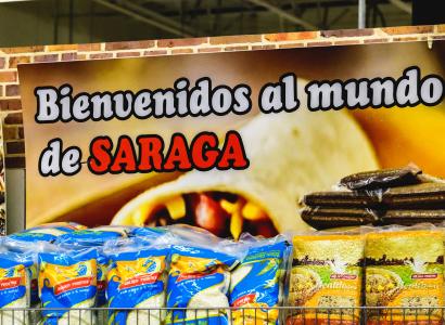 Sign in back of food at a grocery store saying Bienvenidos al de Saraga