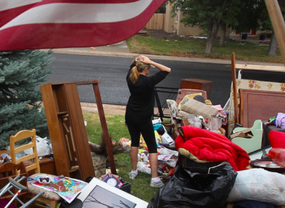 Woman outside in a yard full of furniture after eviction