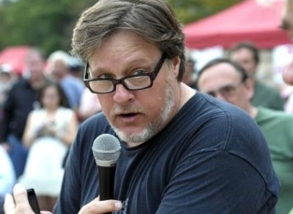 Middle aged white man holding microphone