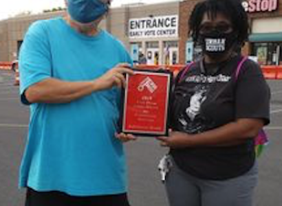 Man and woman holding a plaque