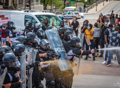 Police spraying a crowd of protestors