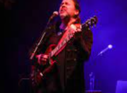 Guy singing with guitar on stage