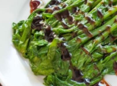 Asparagus on a plate with a brown drizzle across it