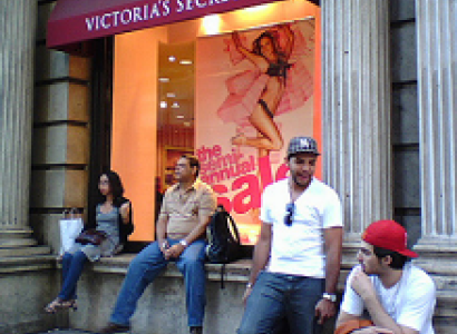 People sitting on a ledge outside a Victoria's Secret store