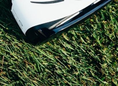 White and black virtual reality goggles laying on grass