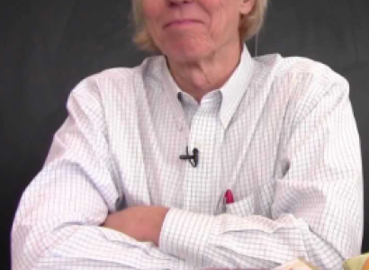 Man in white shirt leaning elbows on table