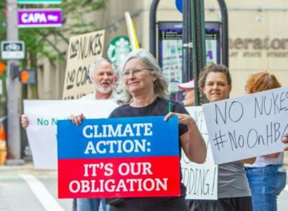 Woman holding a sign saying Climate Action It's our Obligation