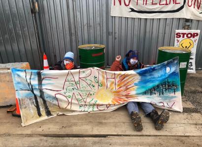 People sitting and holding an Earth Day banner