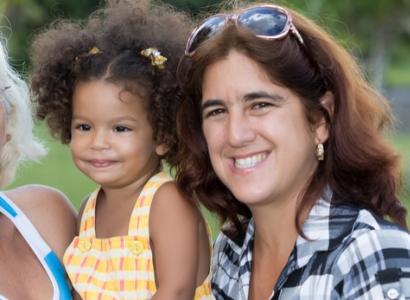 Young black girl with thirty-something white woman with brown hair and sunglasses on her head