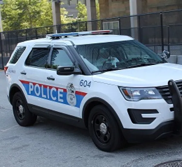 Large white SUV with Police in letters on the side and lights on top