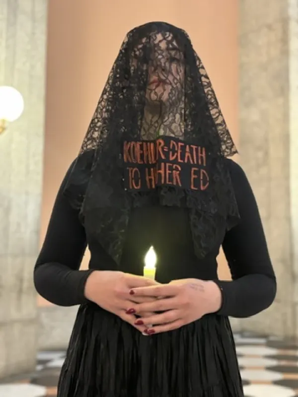 Woman in funeral clothes with a candle