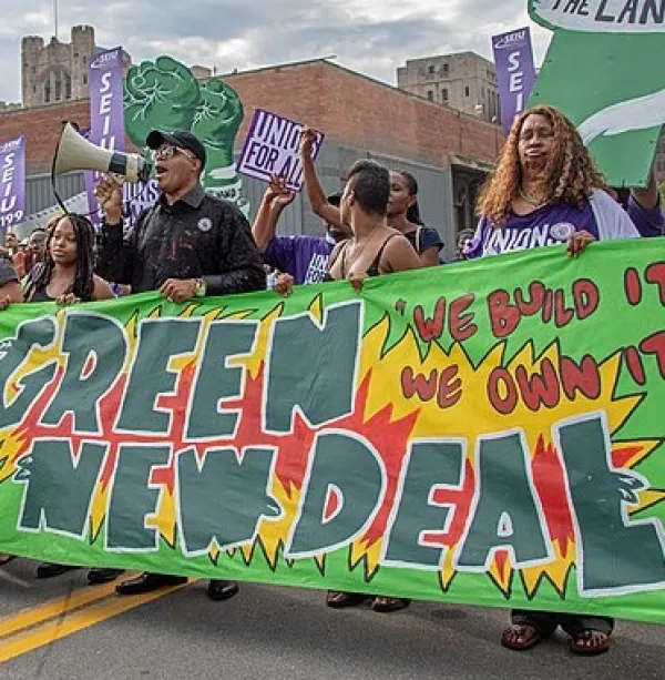 Banner that says Green New Deal and people marching