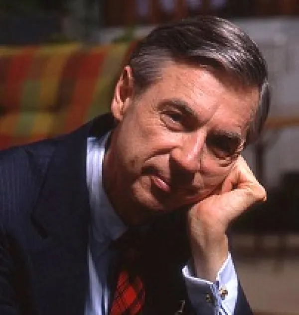 Older white man with dark and gray hair wearing a suit with his head resting on his hand