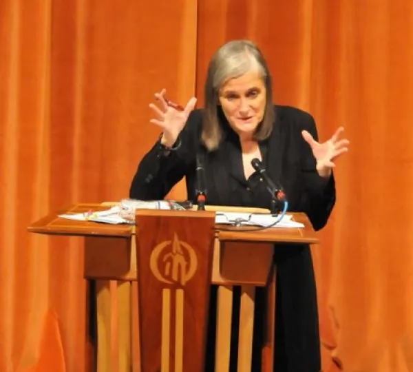 Amy gesturing with both hands at a podium