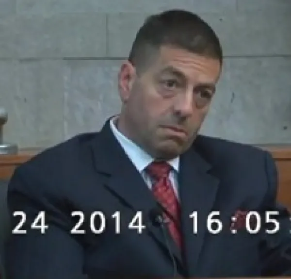 White middle aged man with crew cut and big bags under his eyes wearing a suit looking off to the side with a very worried expression on his face 