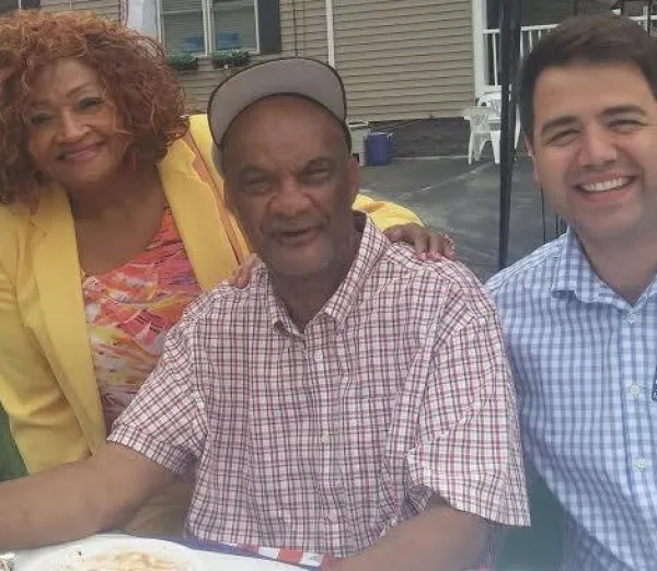 Calvin at a table outside with a woman to his right and man to his left