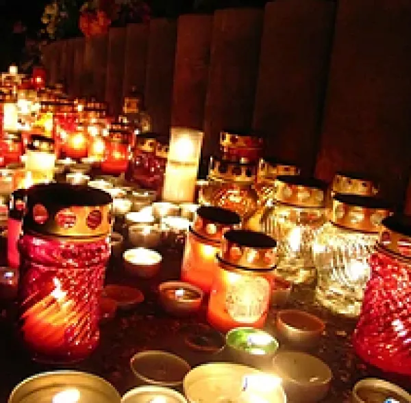 Lots of gold and red candles glowing in the dark