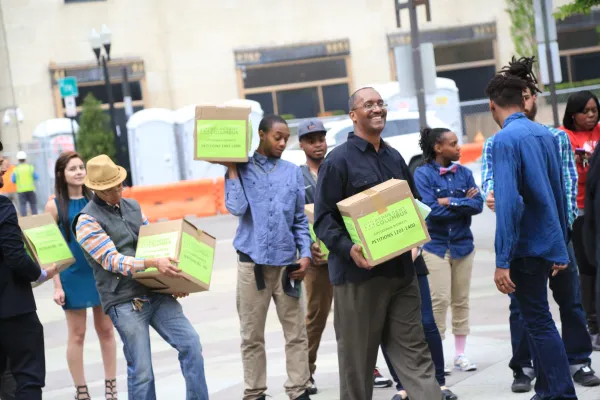 Many people holding boxes