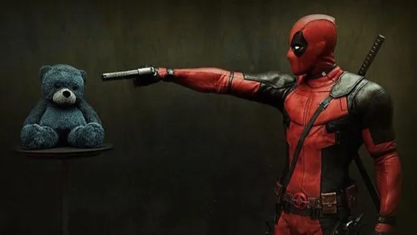 Deadpool character pointing a gun at a teddy bear