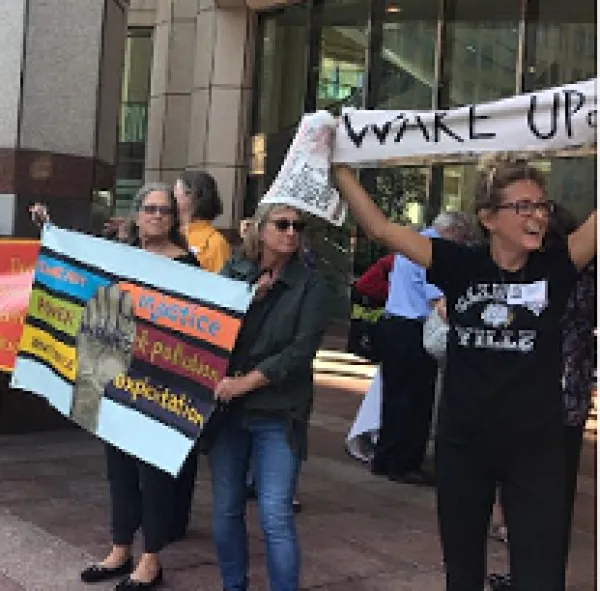 People outside holding banners one saying Wake Up