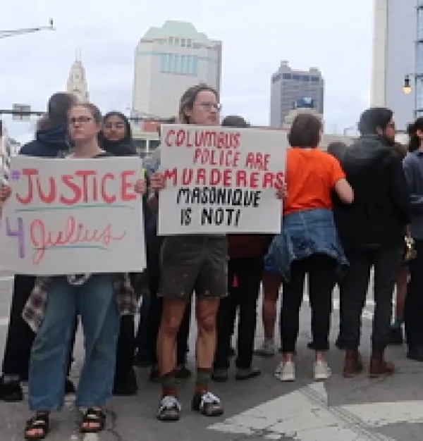 People outside downtown holding signs that say Justice 4 Julius and Columbus Police are murderers Masonique is not